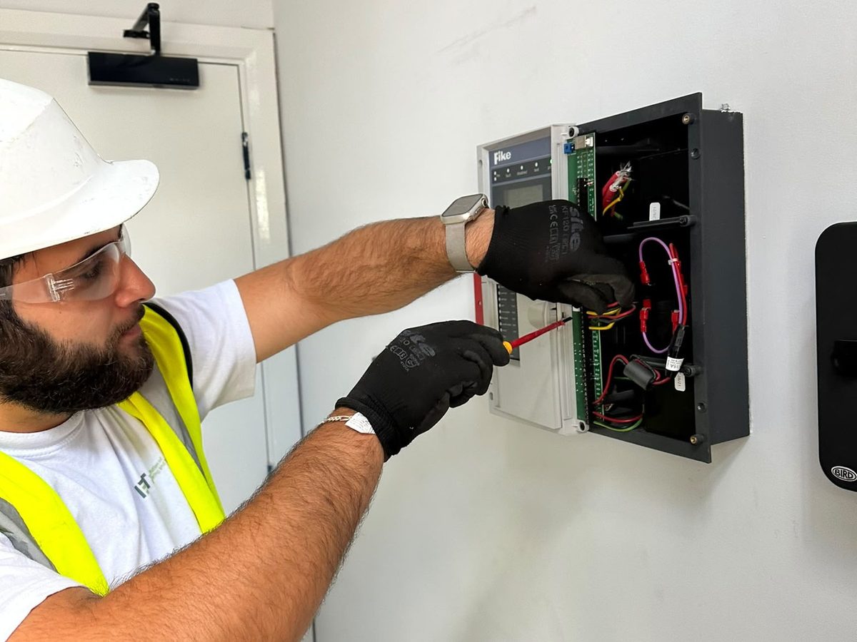 Electrician working on a Fike fire alarm control panel